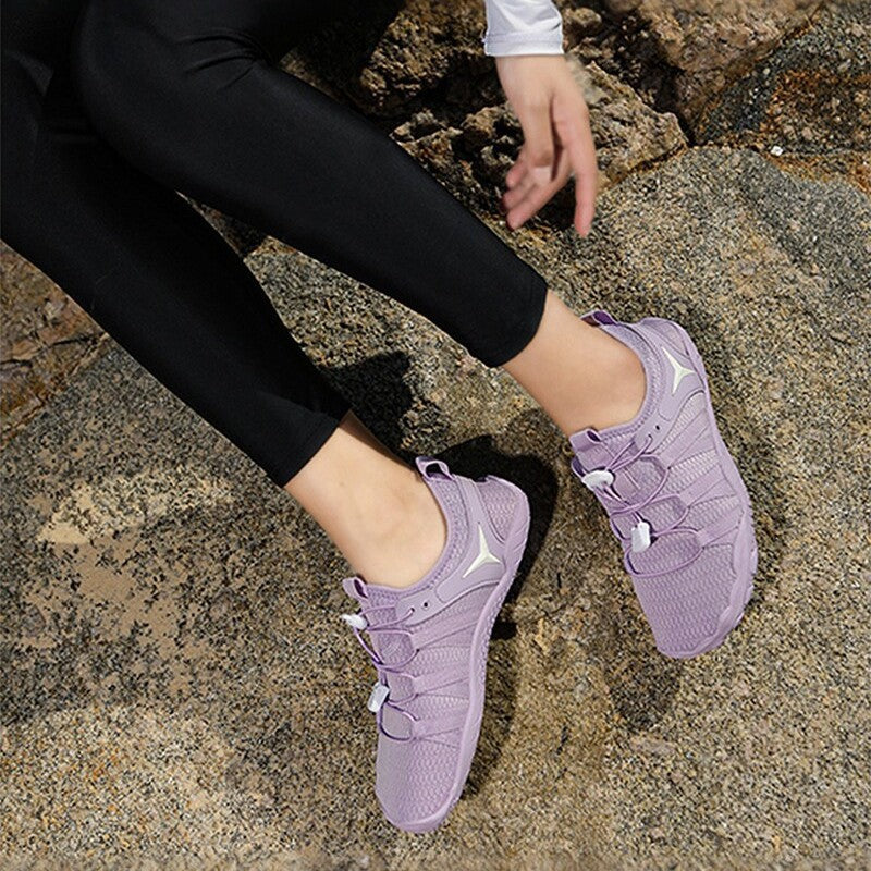 Person wearing purple sneakers on a rocky surface
