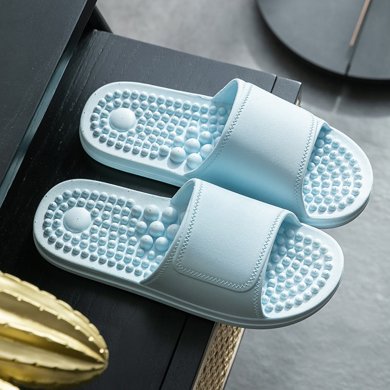 Pair of light blue slippers with textured sole on a dark surface