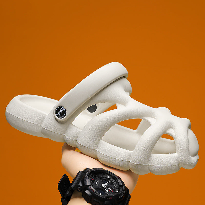 White sandal held by a hand with a black watch on an orange background