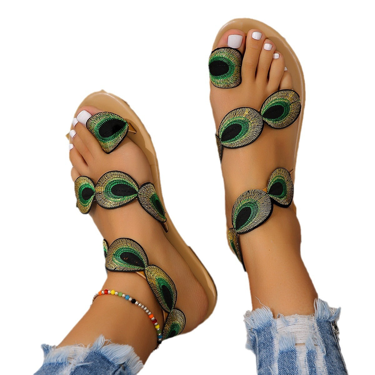 Sandals with peacock feather design on a white background