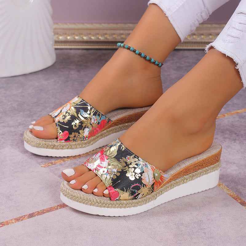 Floral wedge sandals on feet with a neutral background