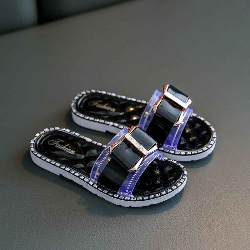Black sandals with purple straps on a gray surface