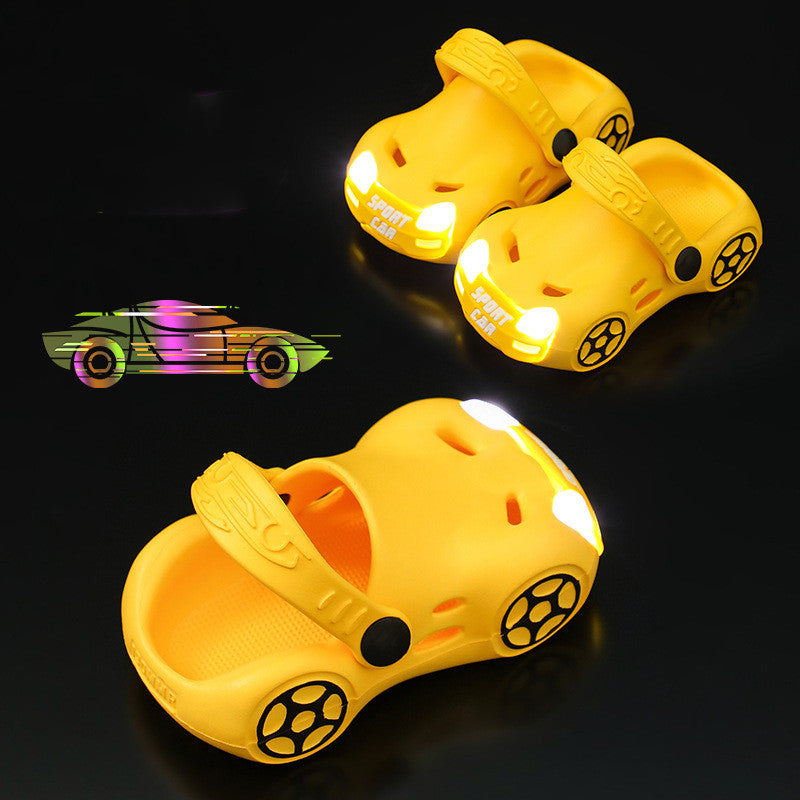 Yellow children's shoes with car design and glowing wheels on a black background