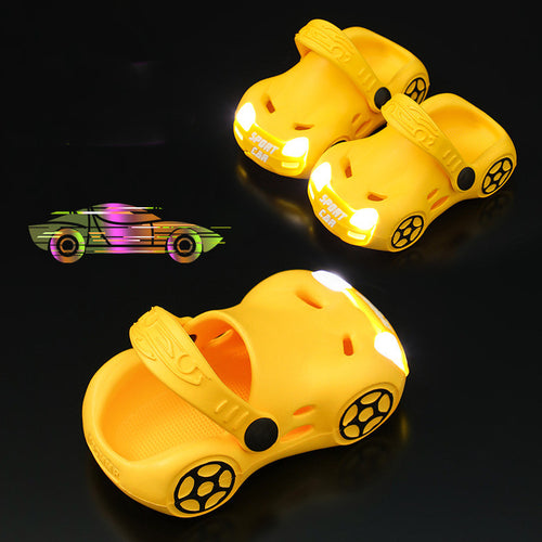 Yellow children's shoes with car design and glowing wheels on a black background