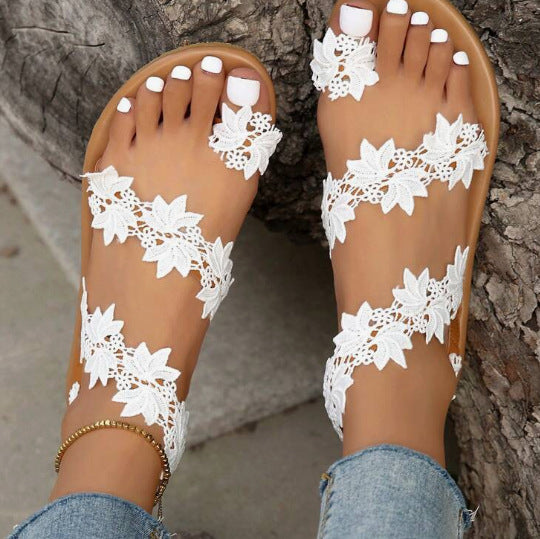 White lace sandals with brown soles on a neutral background