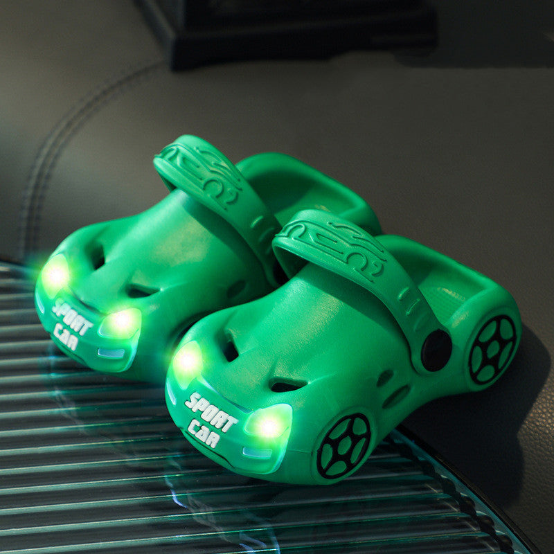 Green toy car lights on a dark surface