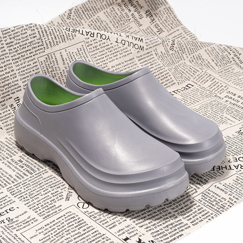 Pair of gray clogs with green insole on a newspaper background
