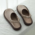 Pair of beige sandals with brown soles on a white fabric background