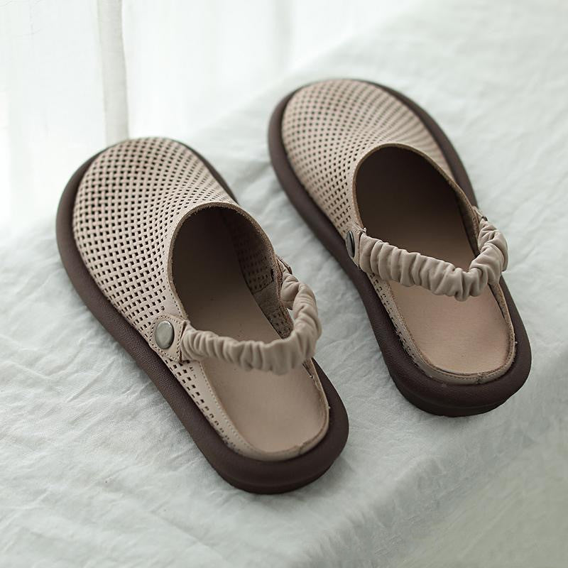 Pair of beige sandals with brown soles on a white fabric background