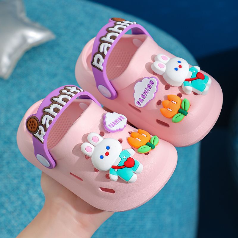 Pink children's sandals with cartoon character decorations on a blue background