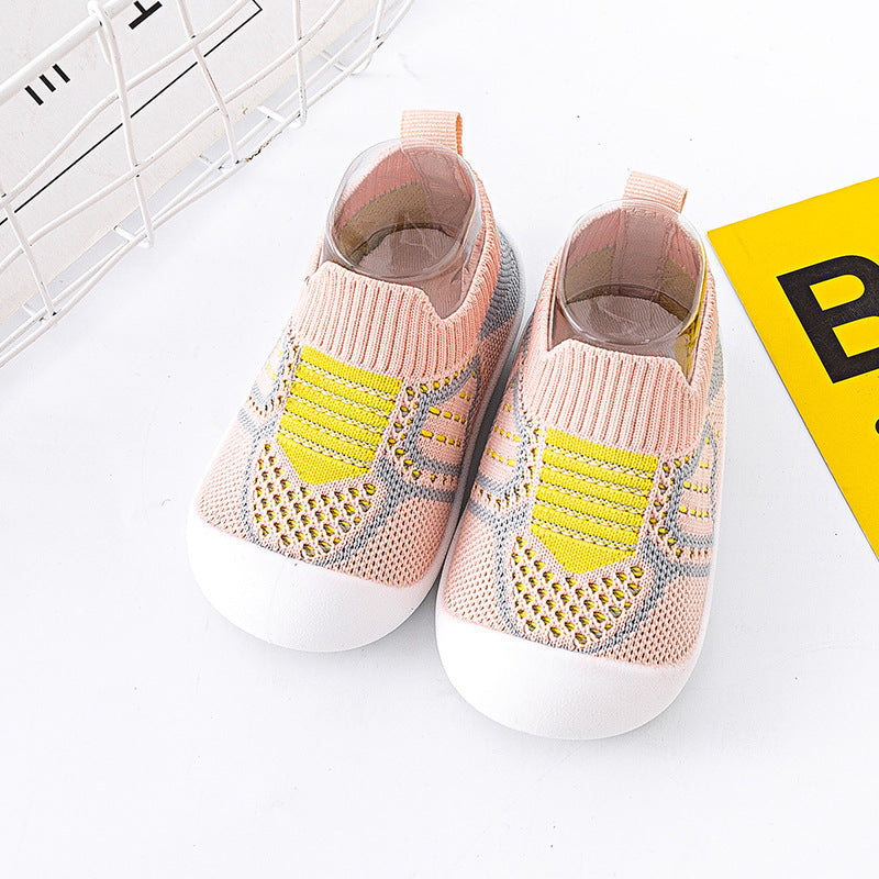 Pair of pink and yellow baby shoes on a white background