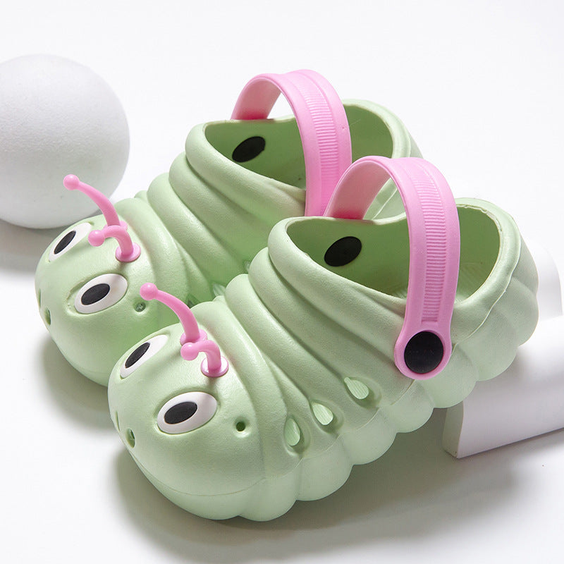 Green caterpillar-shaped shoes with pink accents on a white background