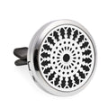 Round metallic car air freshener with black geometric pattern on a white background
