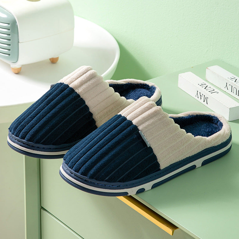 Pair of blue and white slippers on a light green surface with a minimal background.