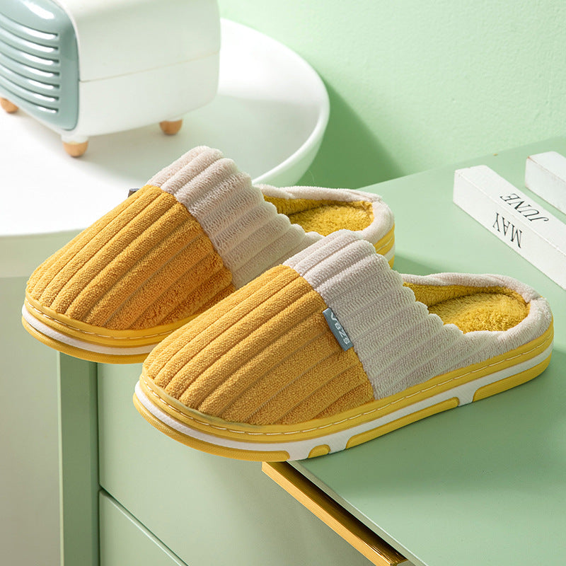 Yellow and gray slippers on a green surface with a blurred background