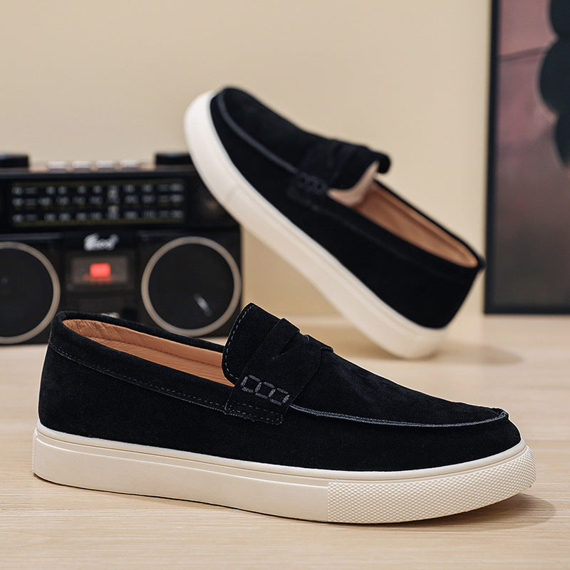 Black loafers with white soles on a wooden surface with a retro radio in the background