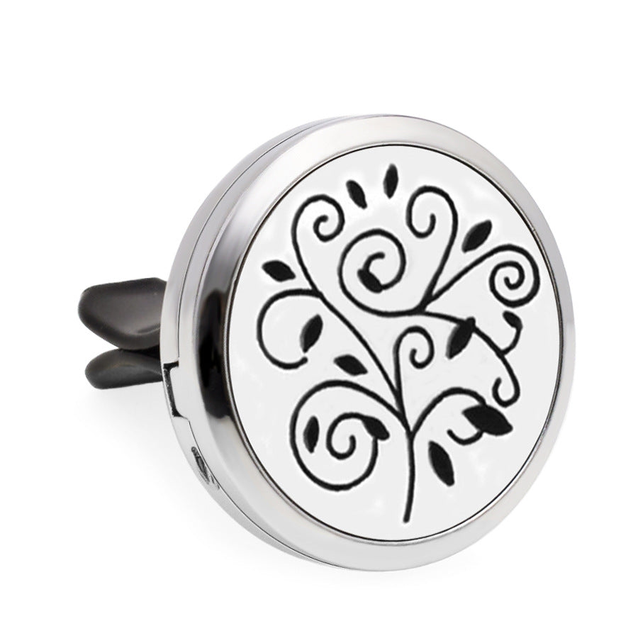 Round silver diffuser with black floral design on a white background