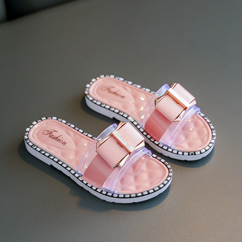 Pink slides with clear straps on a gray surface