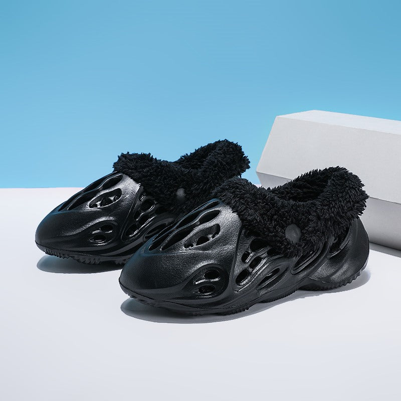 Black futuristic shoes with fuzzy texture on a white platform against a blue background