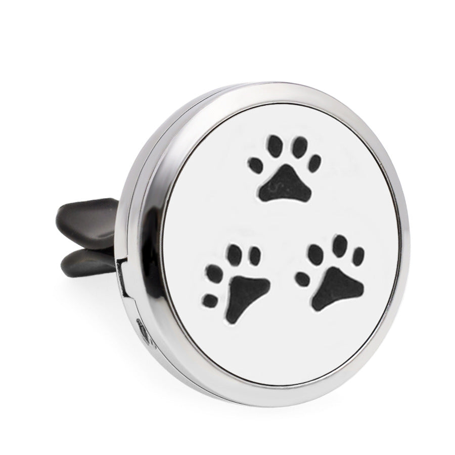 Round metallic object with black paw prints on a white background