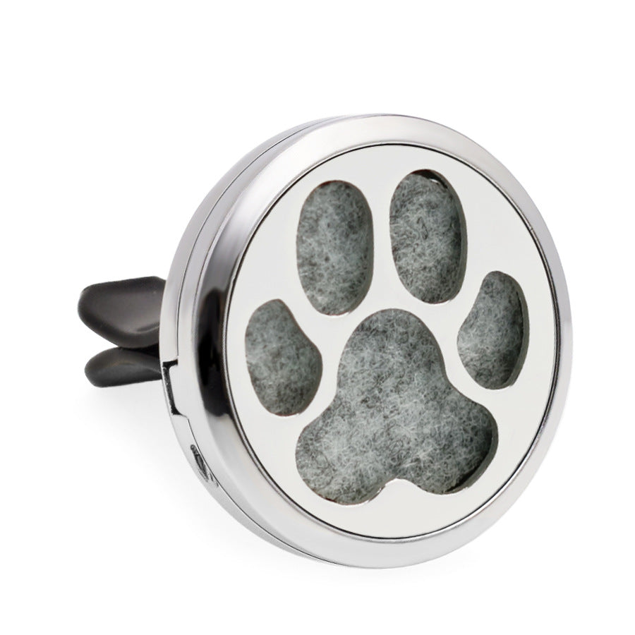 Round silver object with a paw print design on a white background