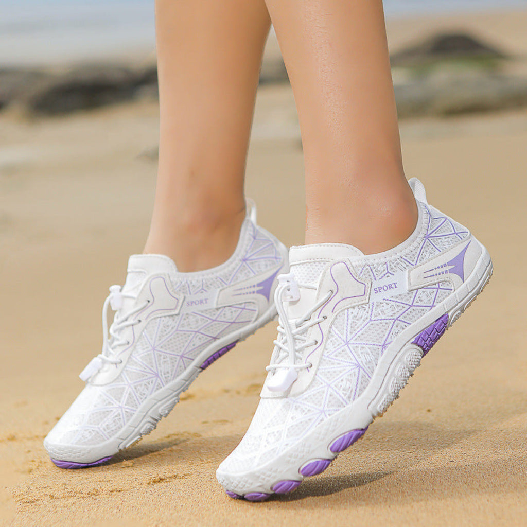 White sneakers with purple accents on a sandy beach